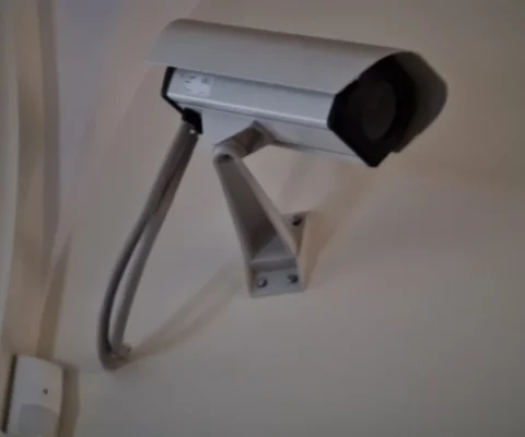 Une caméra de surveillance est fixée au mur dans un intérieur.
