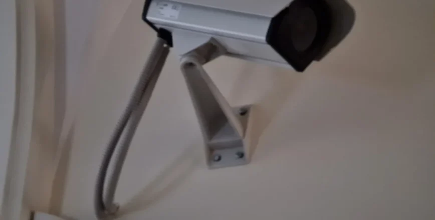 Une caméra de surveillance est fixée au mur dans un intérieur.